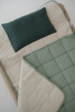 A olive green and beige stripe quilted daycare bedding nap mat with a dark green pillowcase attached. It has a built in matching pillowcase, pillow insert, name tag and carry handle. The daycare bedding nap mat is laid out on a daycare stacker bed frame against a white background.