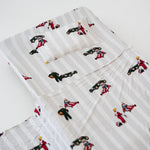 A white and soft grey striped daycare sheet set laid out onto a daycare stacker bed. The print features vintage hand drawn boys dressed in vintage race overalls and helmet next to a vintage race car and driving a vintage go kart. The products are photographed with a white background.