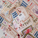 A soft beige and multicolour sheet set packaged in its matching drawstring storage bag displayed ontop of the same daycare sheet set laid out onto a daycare stacker bed. The print features hand drawn geometric. The products are photographed with a white background. shapes with nostalgic images including a horse, vintage pedal bike, tent and camp fire, person fishing along with native trees, flowers and animals. Photographed on a white background.