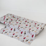 A white and soft grey gingham daycare sheet set laid out onto a daycare stacker bed. The print features vintage hand drawn farm animals including chickens, pigs, little girl walking a horse, a boy pushing his dogs in a wheelbarrow, red barn and cows eating hay out of a tractor and trailer. The products are photographed with a white background.