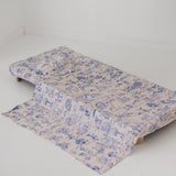 A soft beige and blue daycare sheet set laid out onto a daycare stacker bed. The print features hand drawn outback Australian animals and natives including emu's, crocodiles, kangaroos, koala's, wombats, echidna's with native gum trees and plants. The products are photographed with a white background.