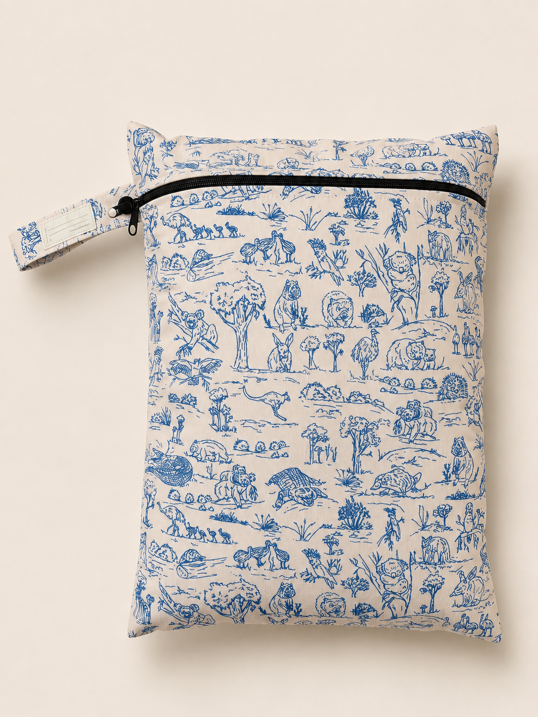 A PUL material zippered daycare wet bag with a blue and beige toile de Jouy pattern featuring Australian outback animals and trees, shown on a light beige background.