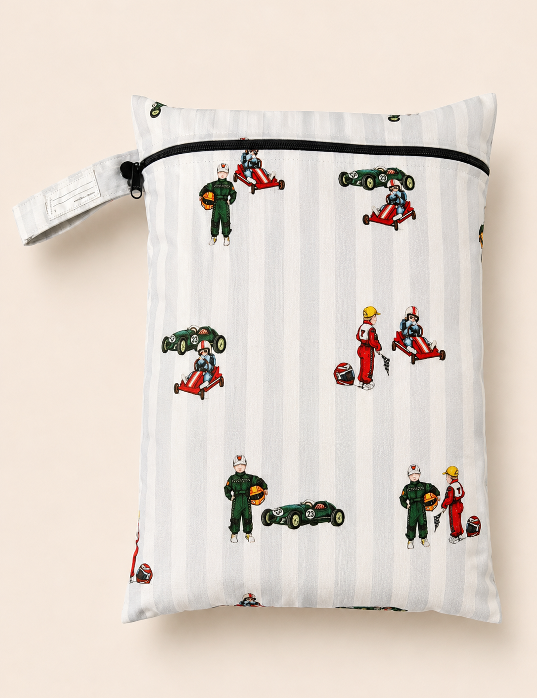 A rectangle PUL fabric daycare wet bag  with a zipper closure and a button loop strap, printed with a hand vintage racing pattern on a light grey and white stripe background. The print includes a boy in a vintage go kart, boy in a green race suit and a vintage race car. Photographed on a soft a beige background.