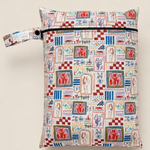 A zippered daycare wet bag with a colourful hand drawn vintage-style illustrated print. A repeating pattern of different abstract drawings with horses, person fishing, campfire, vintage bike with trailer, scorpion and various trees, plants and florals. It features a matching fabric loop strap with a black snap button, set against a solid light beige background.